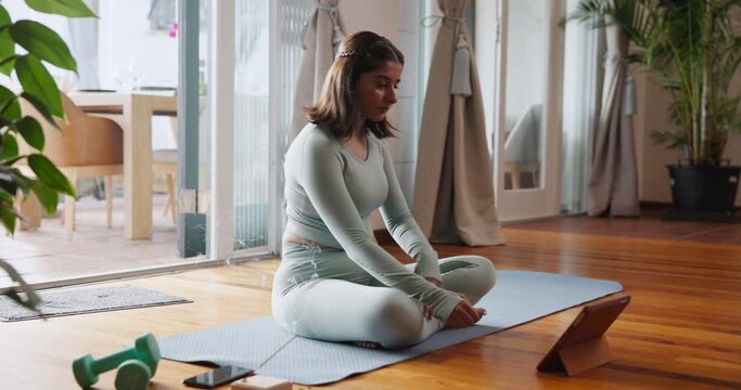 Woman, yoga and stretching with tablet for tutorial, online class or fitness lesson on mat at home. Young female person or yogi in warm up with technology for exercise tips, training steps or workout