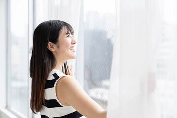カーテンを開ける女性