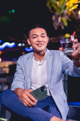 Well dressed young man enjoying a drink at a bar