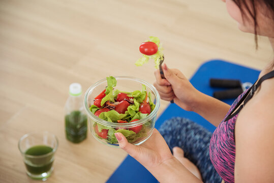 Healthy woman workout holding organic salad bowl healthy lifestyle. Wellness Asian women dressing organic green salad tomato vegetable dish. Beautiful girl healthcare vegan wellness lifestyle concept