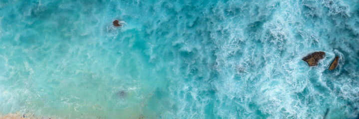 Banner Turquoise ocean sea water white wave pattern splashing deep blue sea. Banner Tropical sea beach Seascape dark background wave splash on rock. Summer Ocean Surface big wave with copy space