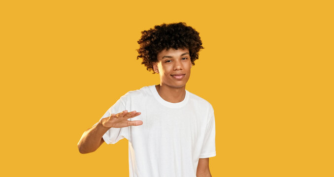 So-so gesture. Dont know. Doubtful skeptic confused disappointed guy not sure hesitating isolated on yellow empty space background.