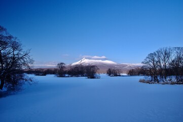 Mount Komagatake under the winter blue sky in Onuma Quasi-National Park in Hokkaido, Japan