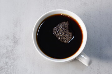 淹れたてのコーヒーが入ったマグカップを、真上から俯瞰した画像
