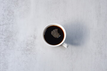 淹れたてのコーヒーが入ったマグカップを、真上から俯瞰した画像
