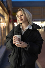 Portrait of a young beautiful blonde girl in an evening spring city.