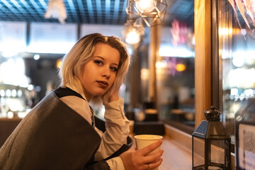 Portrait of a young beautiful blonde girl in an evening spring city.