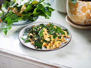 Bai Liang Pad Kai, stir fried Malindjo or Baegu leaves with egg, popular Thai southern dish	