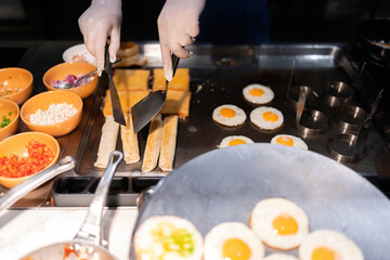 The hotel chef stirs the rolls in a pan and spatula until they are crispy and crispy. For guests waiting to eat Contains condiments such as tomatoes, onions, cilantro, and spring onions.