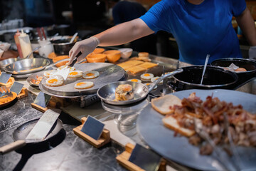 Kitchen staff scoop fried eggs onto plates and serve them to hotel guests. And there are many menus to choose from, such as fried pork and crispy bread, prepared by famous chefs.