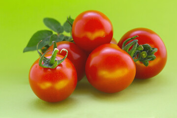 red cherry tomatoes on a vivid green background 