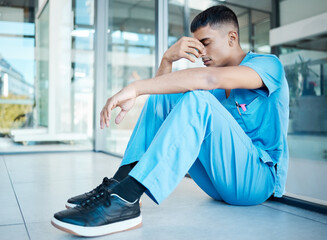 Surgeon, man and sad on floor at hospital for decision, mistake and burnout with stress for...