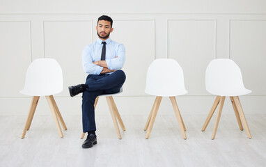 Fototapeta premium Job interview, recruitment and man in waiting room for hiring, opportunity and thinking on chair. Annoyed, businessman and sitting with arms crossed for onboarding, vacant and delay in appointment