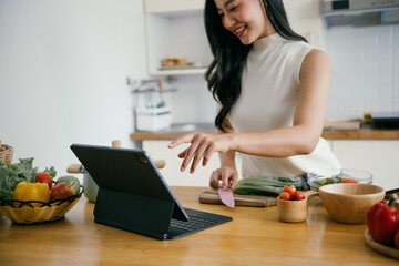 Woman Cooking in Modern Kitchen Using Tablet for Recipe Guidance, Surrounded by Fresh Vegetables and Ingredients