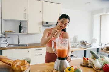 Woman Preparing Smoothie in Modern Kitchen with Fresh Vegetables and Fruits on Countertop