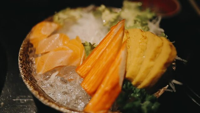 Japanese food set. Raw fish packed in a red, round object. The set consists of salmon, tuna, crab sticks, sweet egg.