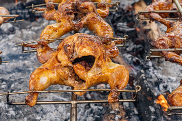 Cooking huli-huli chicken en masse on an outdoor grill,  Huli-huli chicken is a grilled chicken dish in Hawaiian cuisine, prepared by barbecuing a chicken over mesquite wood, Honolulu, Oahu, Hawaii