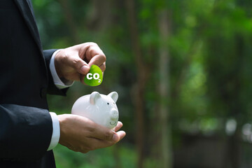 Carbon credit concept with businessman holding leaf green globe reducing saving carbon emissions carbon neutral concept.