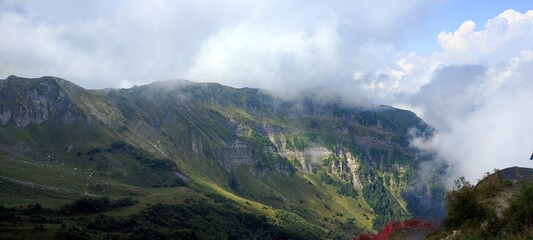 Mountain peak enveloped in clouds, creating majestic atmosphere for adventure in serene wilderness