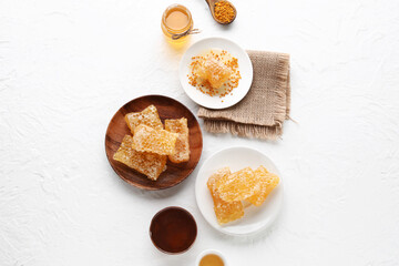 Plates with sweet honeycombs on white background