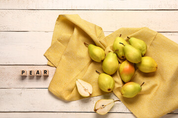 Word PEAR and fresh fruits on white wooden background