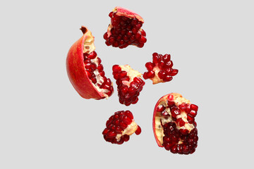 Flying fresh pomegranates on grey background