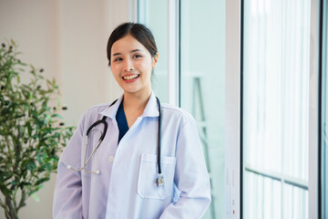  woman in a white lab coat is smiling and holding a stethoscope