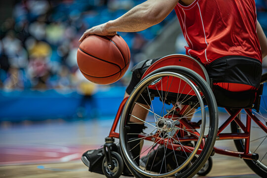 A wheelchair basketball player in a red uniform skillfully drives towards scoring a goal