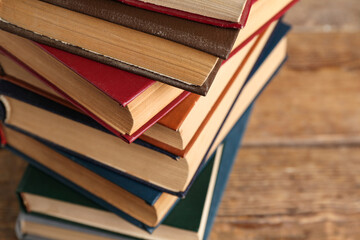 Stack of old hardcover books on wooden background, closeup