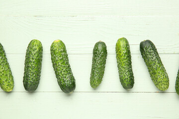 Fresh cucumbers on green wooden background