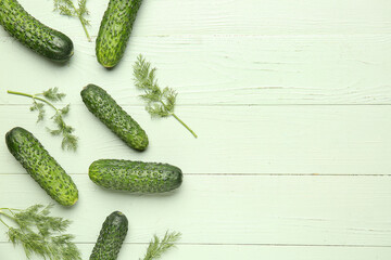 Fresh cucumbers with dill on green wooden background