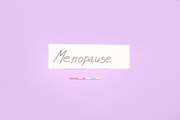 Word MENOPAUSE with pregnancy test on pink background