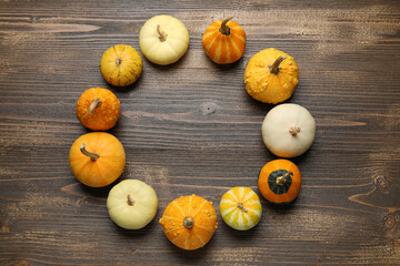 Frame made of different fresh pumpkins on wooden background