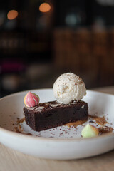 Brownie topped with a scoop of vanilla ice cream.