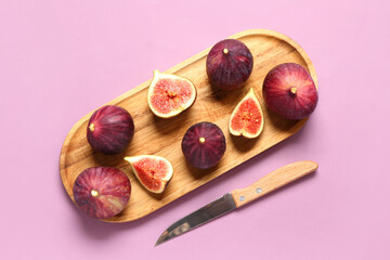 Wooden board with ripe fresh figs and knife on purple background