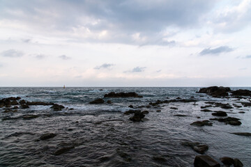 cloudy seascape with rocky beach