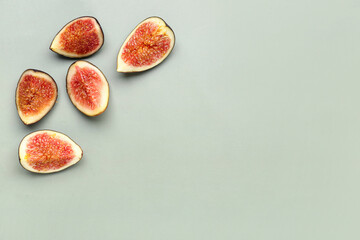 Pieces of fresh ripe figs on green background