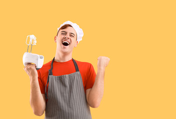 Male confectioner in apron with mixer and whipped meringue on yellow background