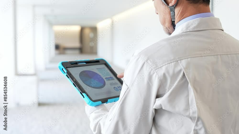 Poster engineer checking a building while looking at a tablet