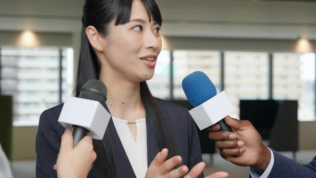 An Asian woman being interviewed in the lobby