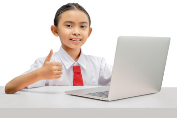 Smiling young student in uniform giving thumbs up while studying on laptop at desk