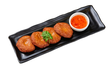 Top view of Thai style fried fish cakes with sweet dipping sauce on black plate isolated on white background.