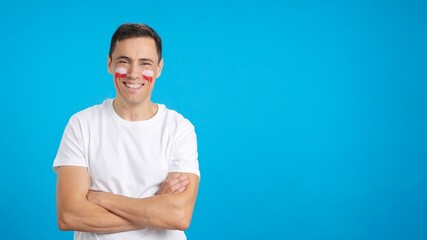 Man standing with polish flag painted on face smiling