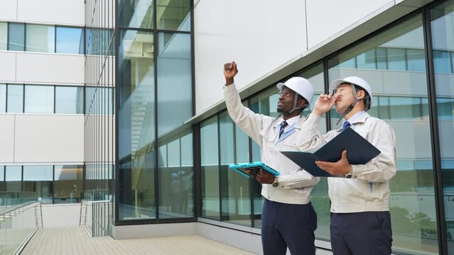 建物を点検する多国籍エンジニアのグループ