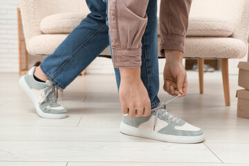 Man trying on stylish sneakers in boutique, closeup