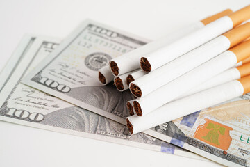 Cigarette on US dollar banknotes, cost, trading, marketing and production, No smoking concept.