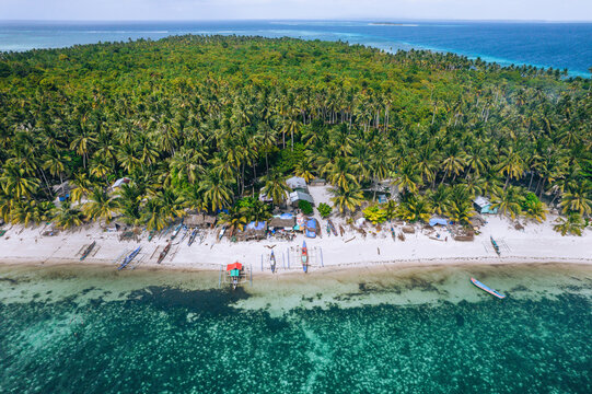 Photo a&eacute;rienne par drone de l'ile de Tangkahan dans les iles Balabac aux Philippines, avec des bateaux amarr&eacute;s et des habitation traditionnel. 