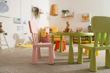 Interior of playroom with toy table and chairs in kindergarten
