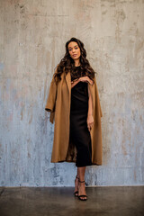 Fototapeta premium Full length of an african american woman standing against grey wall