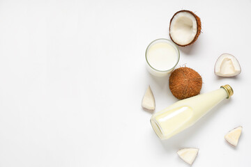 Bottle and glass with coconut milk on white background